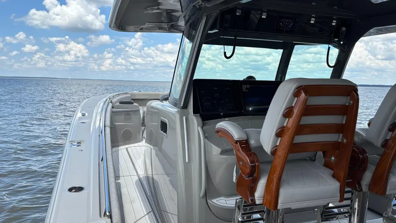 Slide: The Image of 2021 HCB 53 boat interior with luxurious seating and navigation screens on open water. - 36