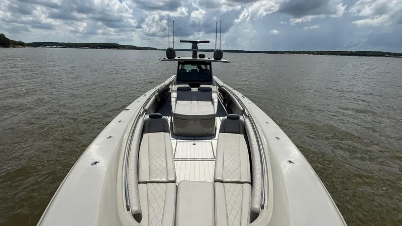 Slide: The Image of 2021 HCB 53 boat on water under cloudy sky, showcasing spacious deck and seating. - 39