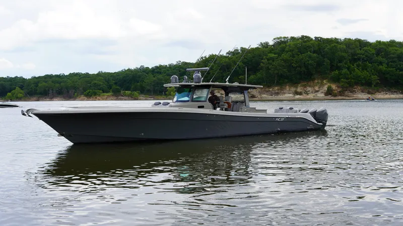 Slide: The Image of 2021 HCB 53 boat on calm water with lush green shoreline in the background. - 4