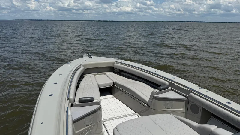 Slide: The Image of Luxury seating on 2021 HCB 53 boat, overlooking calm waters and cloudy sky. - 42