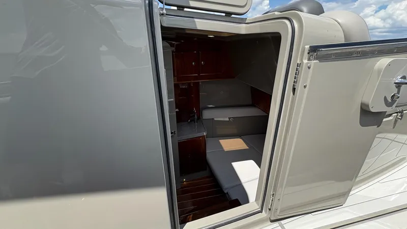 Slide: The Image of 2021 HCB 53 yacht cabin interior with open door, showcasing luxurious seating and wood finishes. - 45