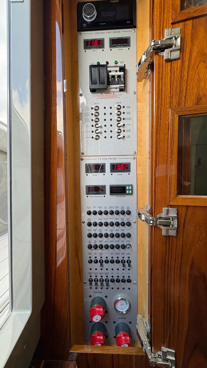 Slide: The Image of Electrical control panel on a 2021 HCB 53 boat, featuring switches and gauges. - 48
