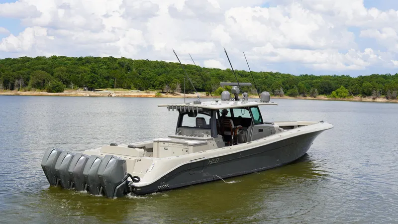 Slide: The Image of 2021 HCB 53 boat with multiple engines on a calm lake, surrounded by lush greenery. - 7