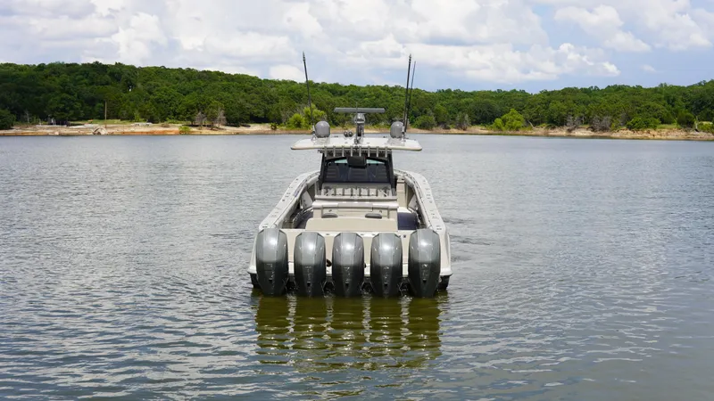 Slide: The Image of 2021 HCB 53 boat with multiple engines on a calm lake, surrounded by lush greenery. - 9