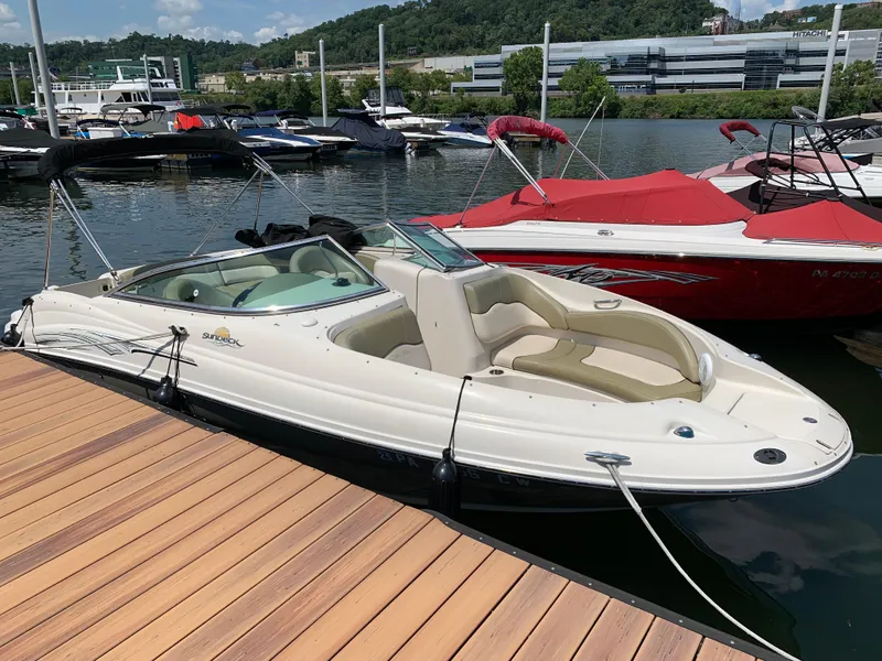 The Image of 2005 Sea Ray 220 Sundeck boat docked at a marina, surrounded by other boats. - 1