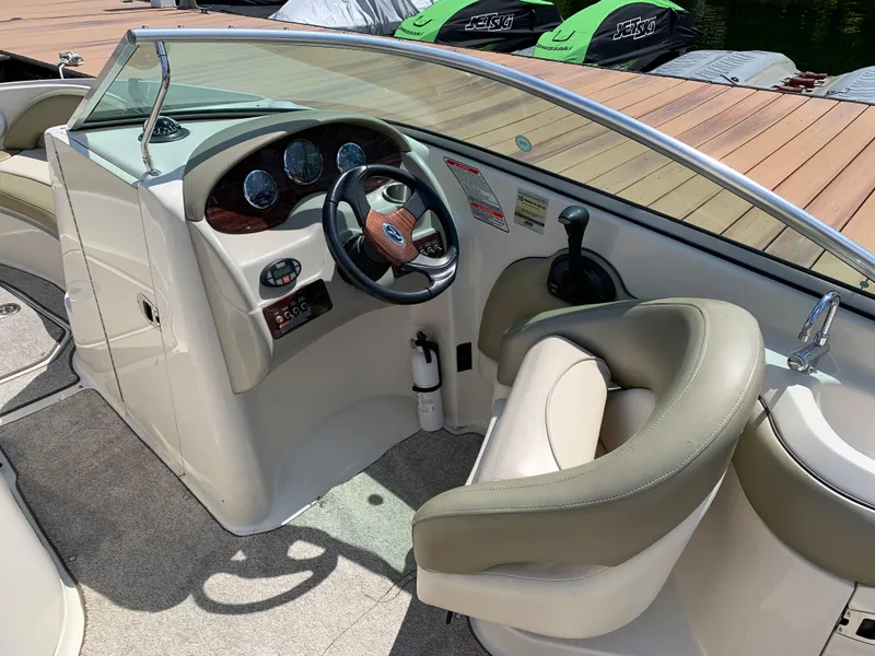Slide: The Image of 2005 Sea Ray 220 Sundeck boat cockpit with steering wheel and dashboard controls. - 3