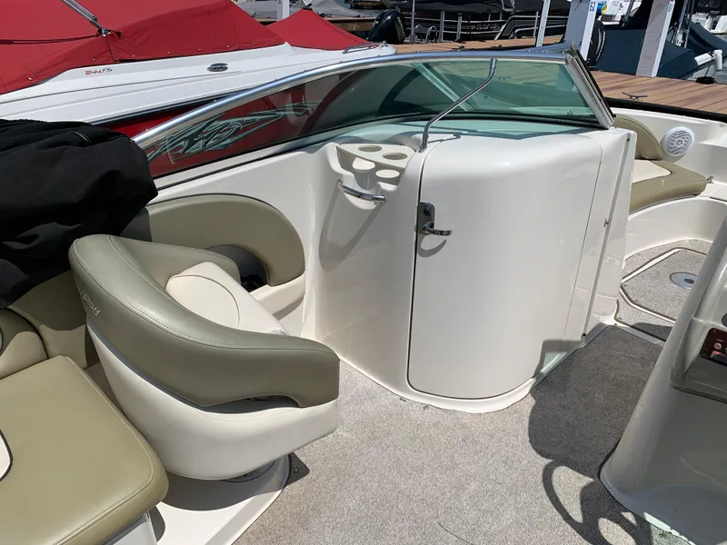Slide: The Image of 2005 Sea Ray 220 Sundeck interior with beige seating and cup holders. - 6