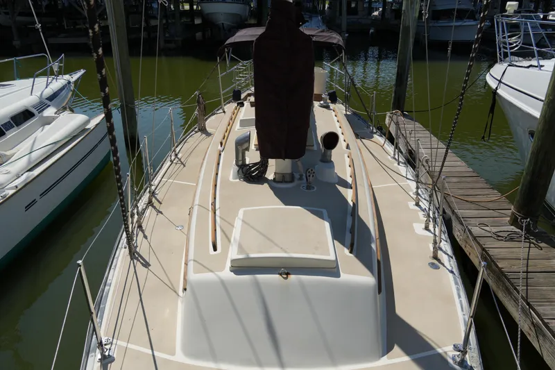 Slide: The Image of 1970 Cheoy Lee 38A sailboat docked, showcasing deck and rigging. - 14