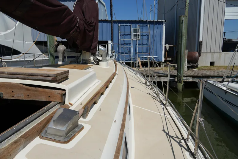 Slide: The Image of 1970 Cheoy Lee 38A sailboat deck view at marina, showcasing classic design and wooden details. - 16