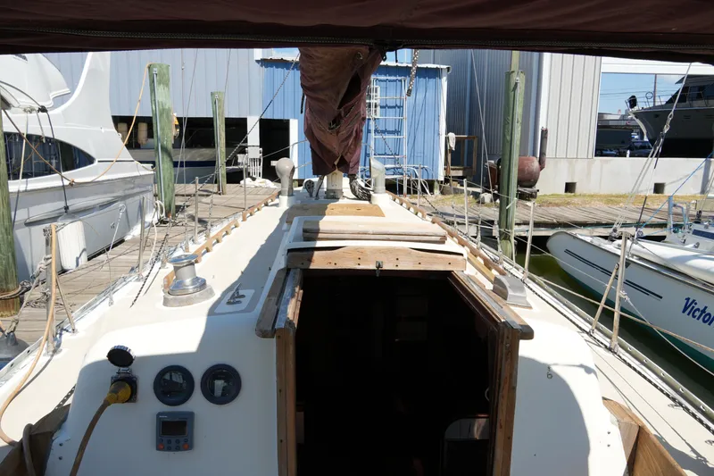 Slide: The Image of 1970 Cheoy Lee 38A sailboat docked, showing deck and cabin entrance. - 18