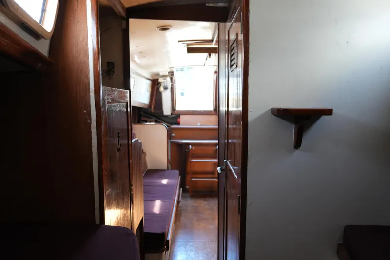 Slide: The Image of Interior of a 1970 Cheoy Lee 38A sailboat, featuring wooden cabinetry and seating. - 21