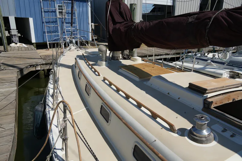 Slide: The Image of 1970 Cheoy Lee 38A sailboat docked, showcasing deck and rigging details. - 7