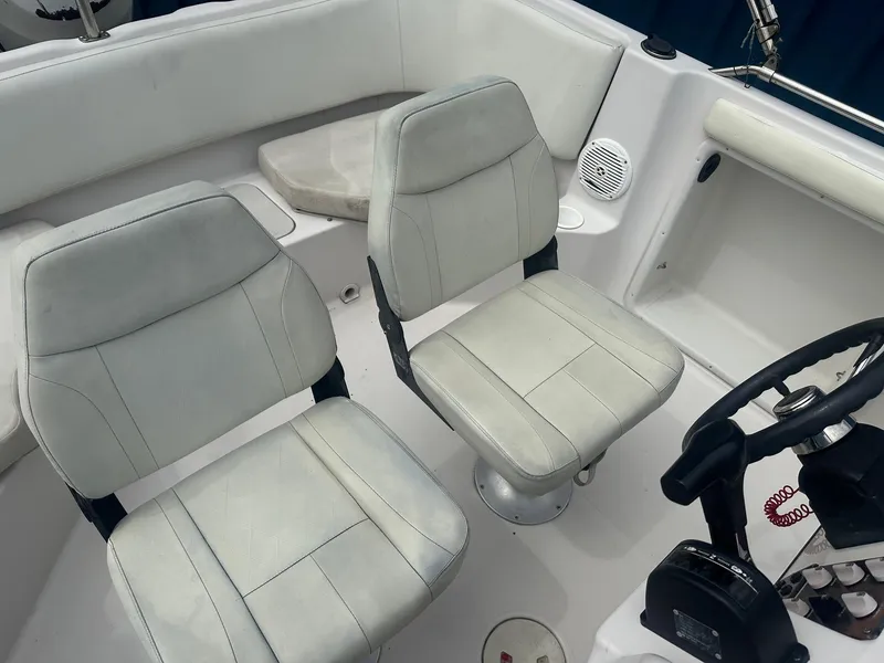Slide: The Image of 2003 Godfrey Hurricane FD211 boat interior with white seating and steering console. - 5