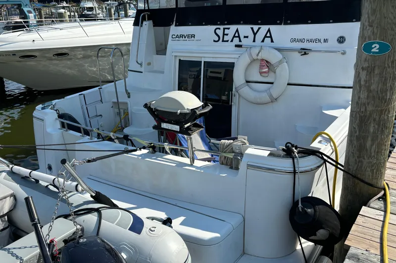 Slide: The Image of 2002 Carver 444 Cockpit Motor Yacht docked, featuring a grill and life preserver. - 11