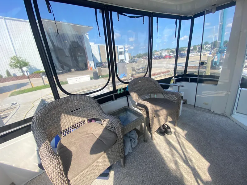 Slide: The Image of Interior of 2002 Carver 444 Cockpit Motor Yacht with wicker chairs and large windows. - 15