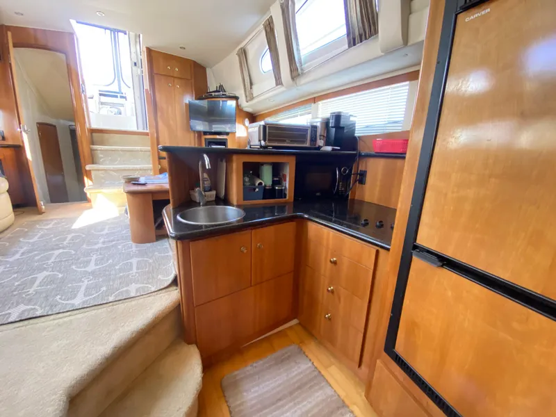 Slide: The Image of Interior of 2002 Carver 444 Cockpit Motor Yacht with kitchen and stairs. - 17