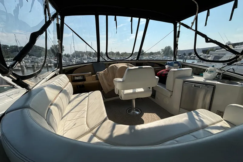 Slide: The Image of 2002 Carver 444 Cockpit Motor Yacht interior with white seating and marina view. - 6