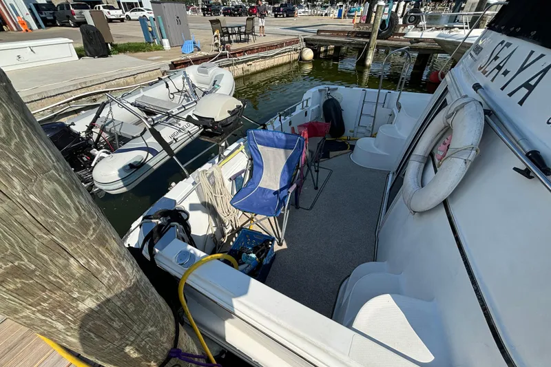 Slide: The Image of 2002 Carver 444 Cockpit Motor Yacht docked with inflatable boat and deck chairs. - 10