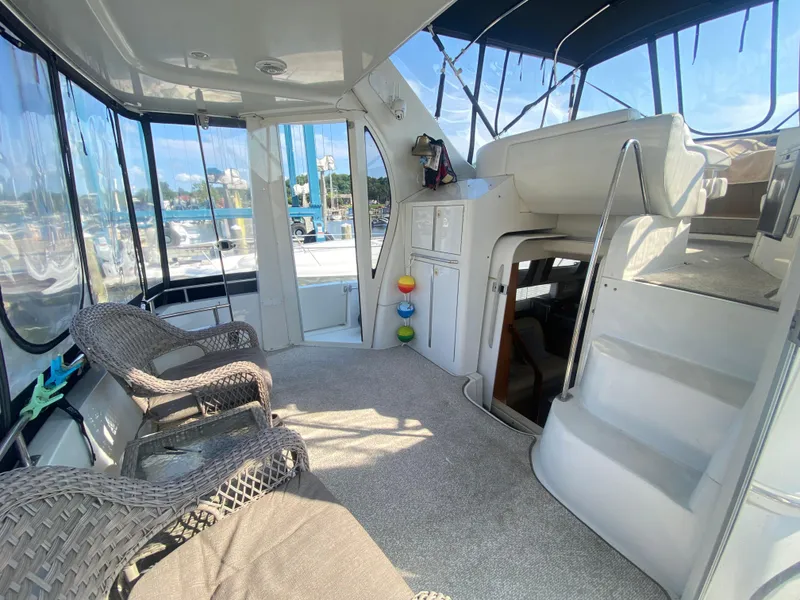 Slide: The Image of 2002 Carver 444 Cockpit Motor Yacht interior with wicker chairs and carpeted flooring. - 12