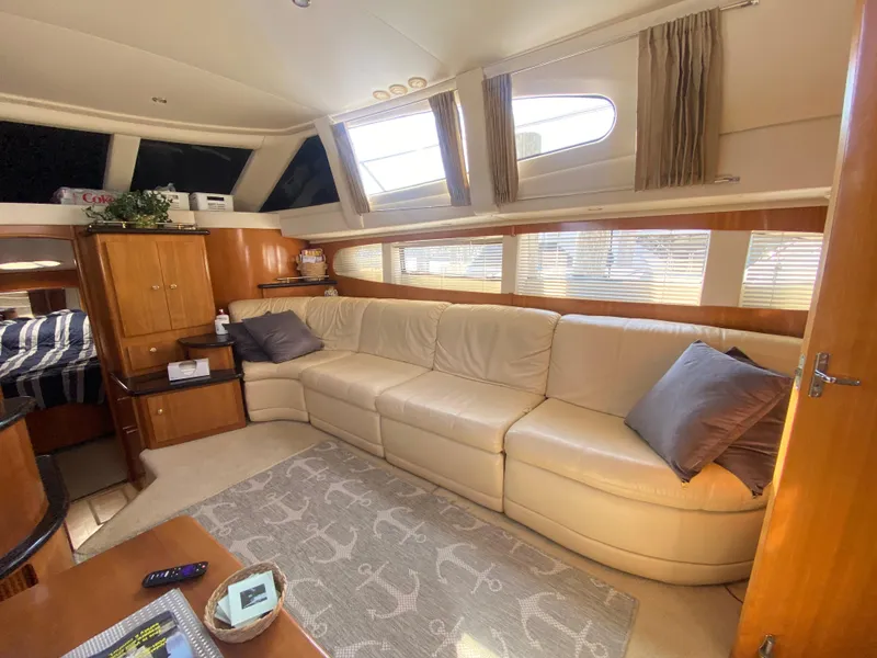 Slide: The Image of Interior of 2002 Carver 444 Cockpit Motor Yacht with beige leather sofa and nautical decor. - 16