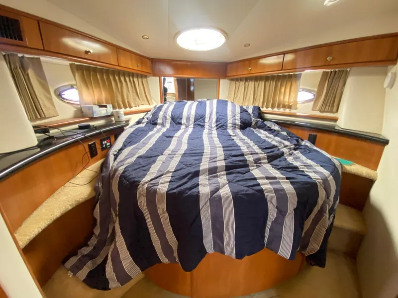 Slide: The Image of Luxurious bedroom in 2002 Carver 444 Cockpit Motor Yacht with striped bedding. - 19