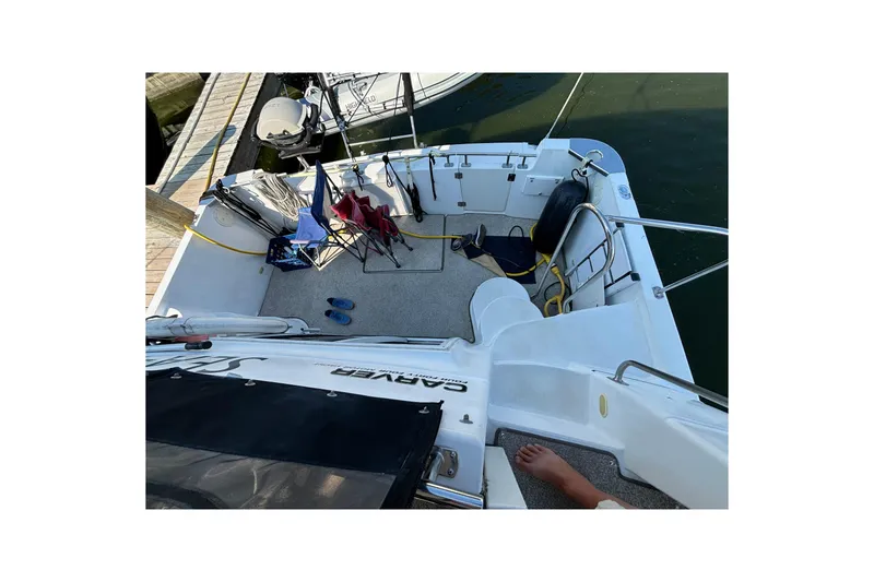 Slide: The Image of 2002 Carver 444 Cockpit Motor Yacht docked, featuring spacious deck with chairs and accessories. - 9