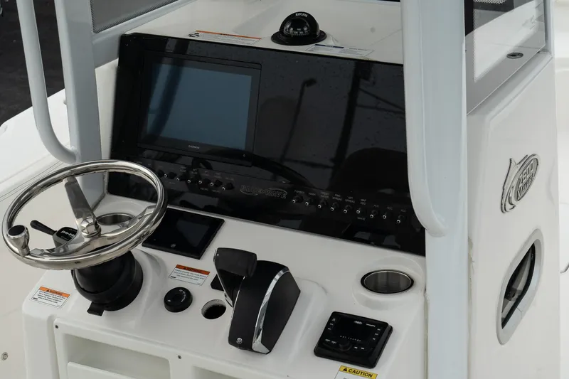 Slide: The Image of 2023 Blue Wave 2600 Makaira boat console with steering wheel and control panel. - 16