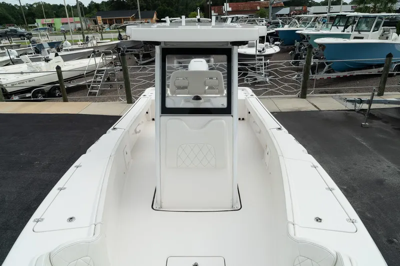 Slide: The Image of 2023 Blue Wave 2600 Makaira boat, white deck, marina background, center console view. - 20