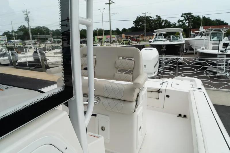 Slide: The Image of 2023 Blue Wave 2600 Makaira boat interior with seating and console, docked at marina. - 21