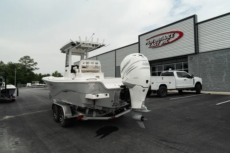 Slide: The Image of 2023 Blue Wave 2600 Makaira boat with outboard motor at dealership parking lot. - 6