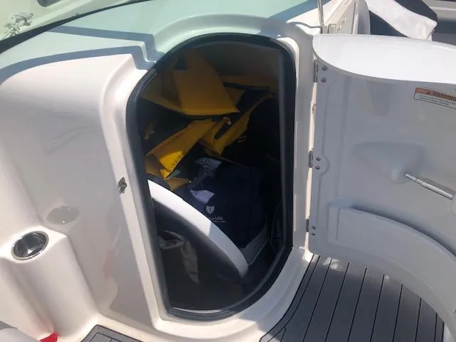 Slide: The Image of Storage compartment on a 2022 NauticStar 243 DC boat, containing life jackets and gear. - 11