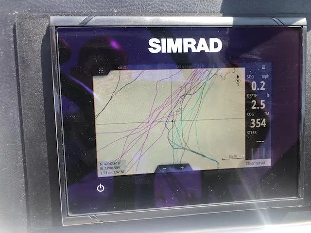 Slide: The Image of Simrad navigation display on 2022 NauticStar 243 DC boat showing route and data. - 13