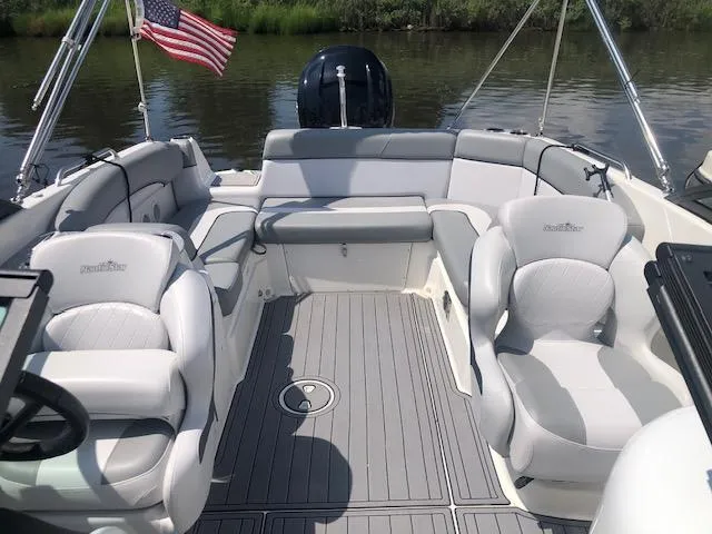 Slide: The Image of 2022 NauticStar 243 DC boat interior with plush seating and American flag. - 2