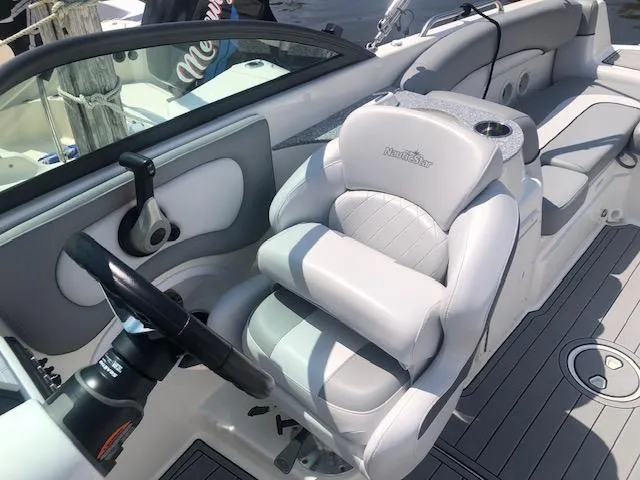 Slide: The Image of 2022 NauticStar 243 DC boat interior with plush seating and steering wheel. - 7
