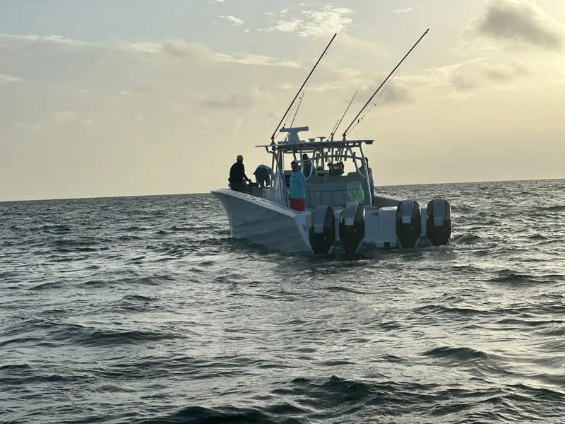 Slide: The Image of 2021 SeaHunter 41 CTS boat on open water at sunset with fishing rods. - 12