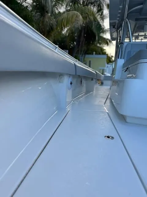 Slide: The Image of 2021 SeaHunter 41 CTS boat deck with sleek design and palm trees in background. - 16