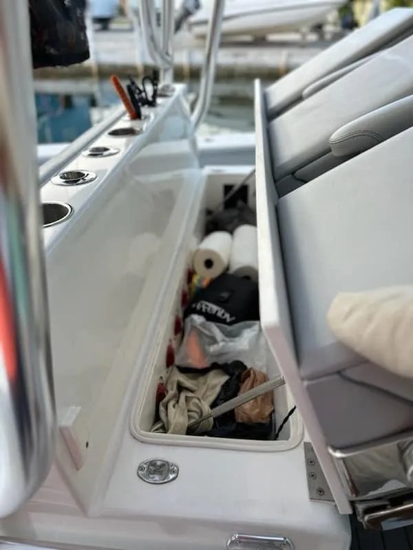 Slide: The Image of Open storage compartment on 2021 SeaHunter 41 CTS boat, showing various items inside. - 21