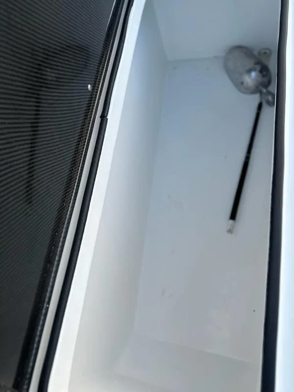 Slide: The Image of 2021 SeaHunter 41 CTS storage compartment with a black handle and metallic fixture. - 23