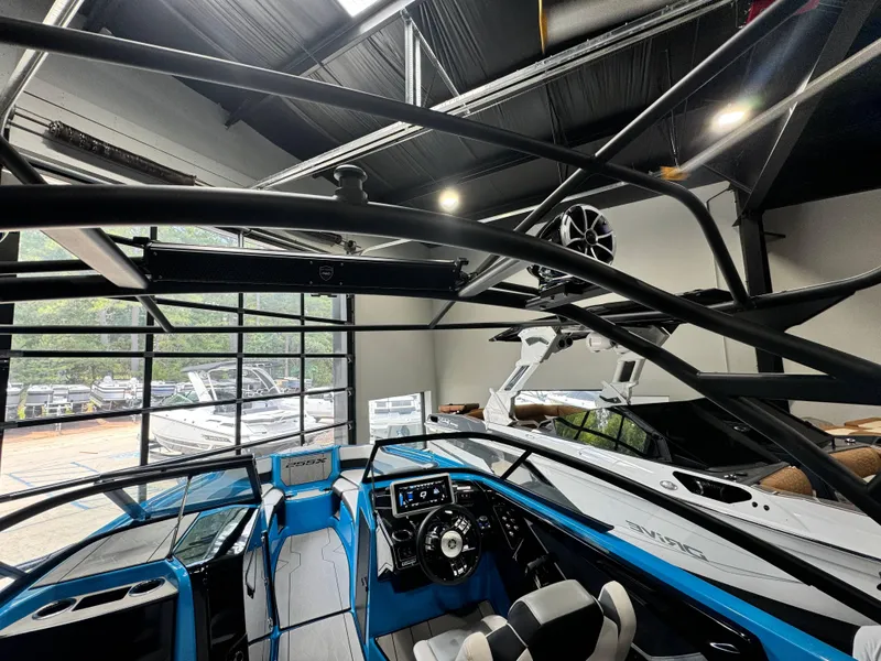 Slide: The Image of 2022 Yamaha Boats 255XD interior, showcasing sleek design and advanced controls in a showroom setting. - 18