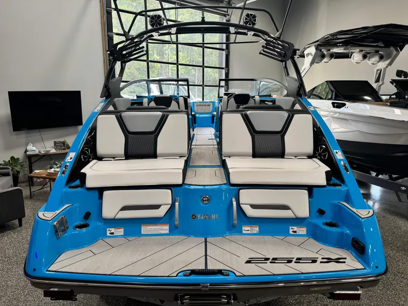 Slide: The Image of 2022 Yamaha Boats 255XD, blue exterior, luxury seating, modern design, indoor showroom display. - 20