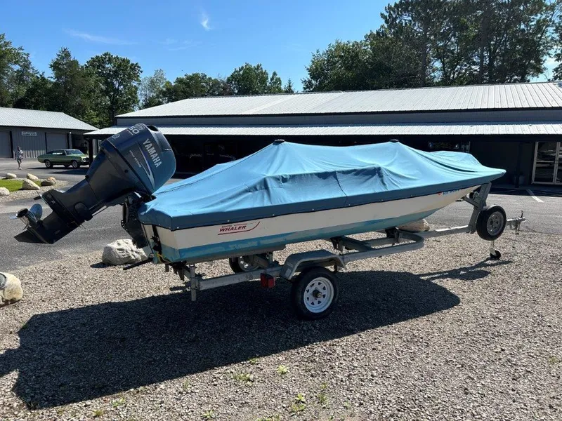 Slide: The Image of 1982 Boston Whaler Sport 15 boat with blue cover on trailer, parked outdoors. - 3