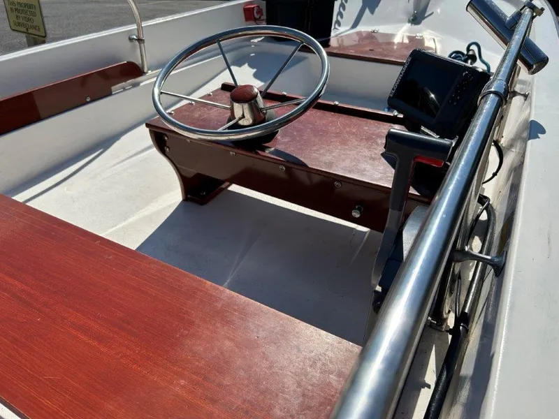 Slide: The Image of 1982 Boston Whaler Sport 15 boat interior with wooden seats and steering wheel. - 6