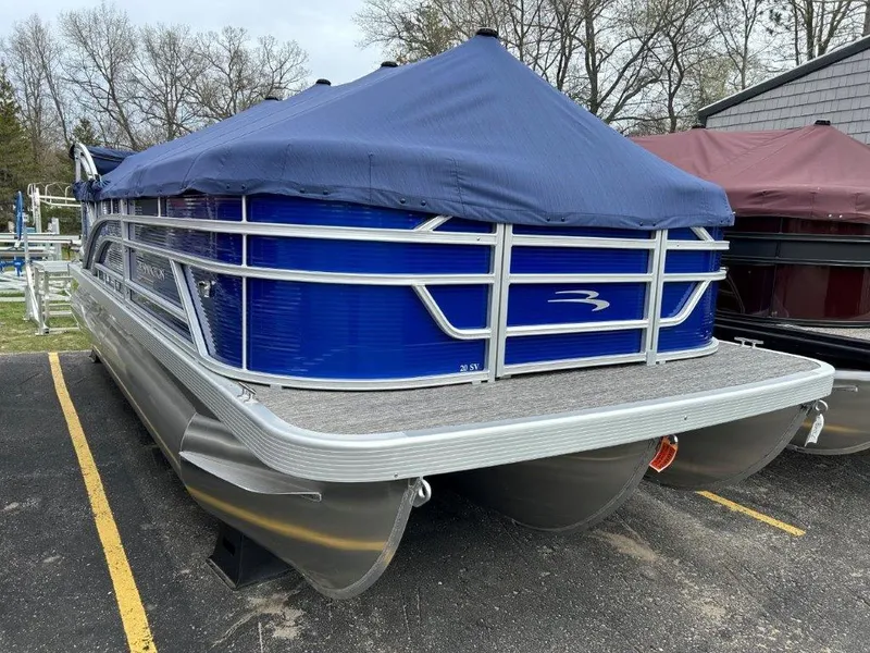 Slide: The Image of 2024 Bennington 20SVSRSPS pontoon boat with blue cover in parking lot. - 1