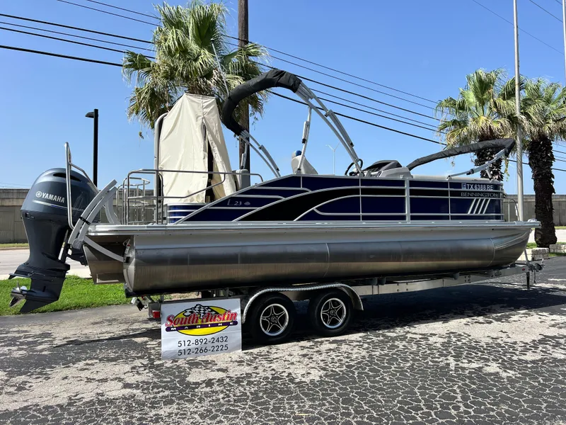 The Image of 2022 Bennington 23LSB pontoon boat on trailer, parked outdoors. - 1