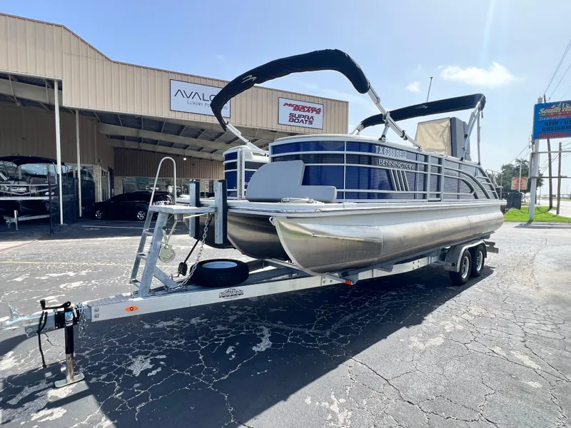 Slide: The Image of 2022 Bennington 23LSB pontoon boat on trailer outside dealership. - 4