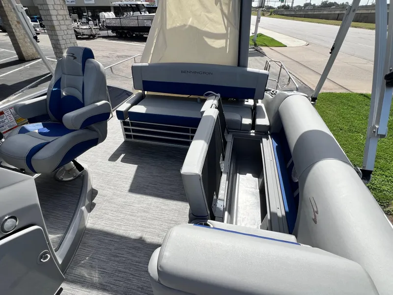 Slide: The Image of 2022 Bennington 23LSB pontoon boat interior with gray seating and storage compartments. - 7