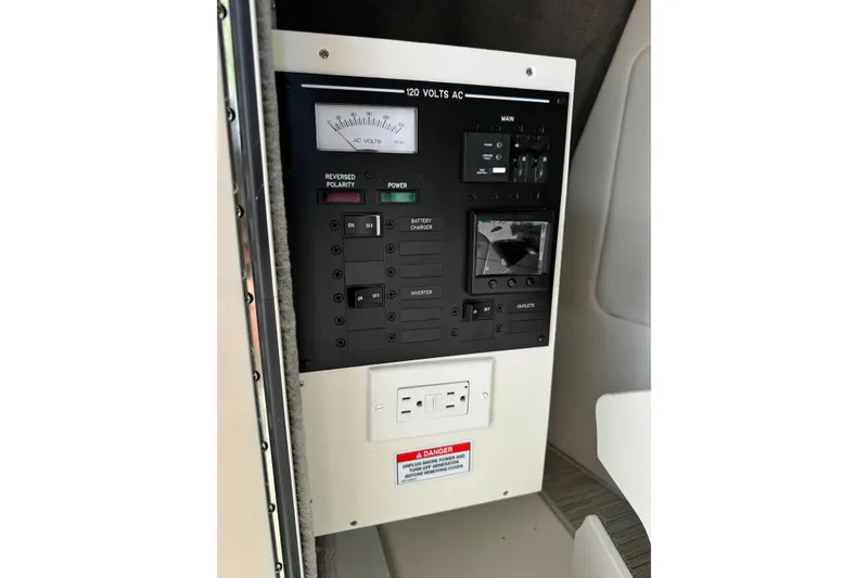 Slide: The Image of Control panel of 2023 Sea Ray SDX 290 Outboard boat, featuring AC voltage meter and switches. - 22
