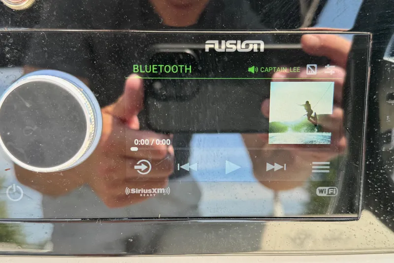 Slide: The Image of Fusion marine stereo display on 2023 Sea Ray SDX 290 Outboard, showing Bluetooth connectivity. - 24