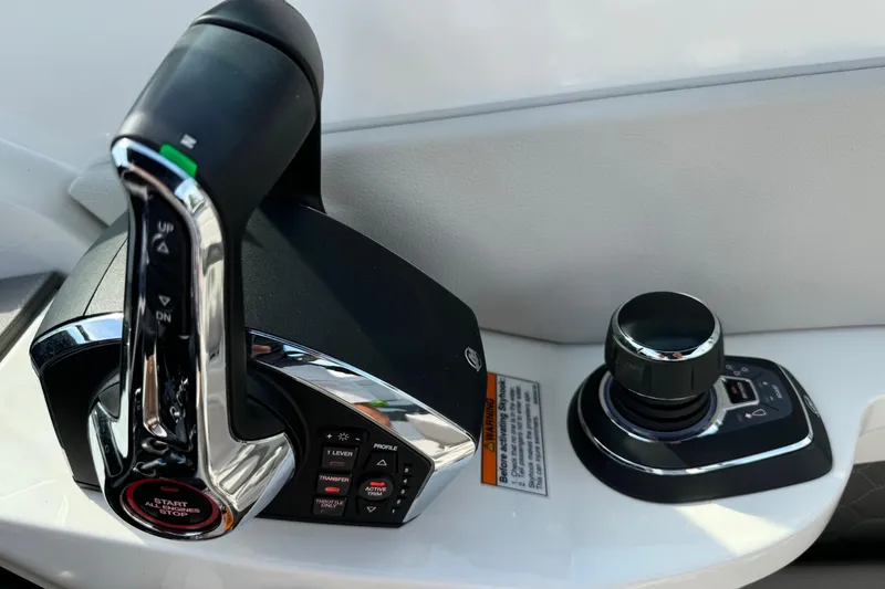Slide: The Image of 2023 Sea Ray SDX 290 Outboard throttle and joystick controls, close-up view. - 9