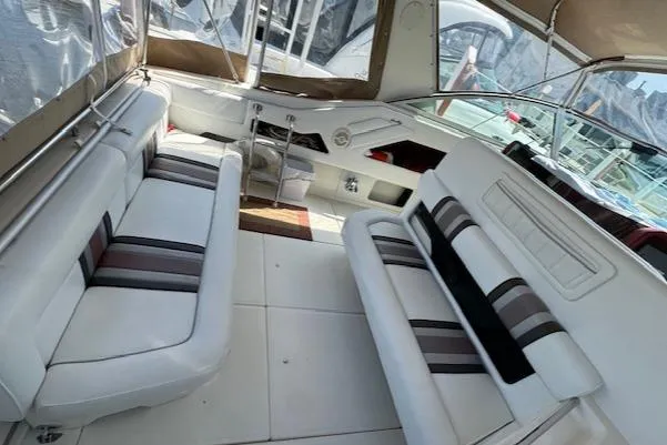 Slide: The Image of 1990 Sea Ray 350 Sundancer interior with white and striped seating, spacious layout. - 12